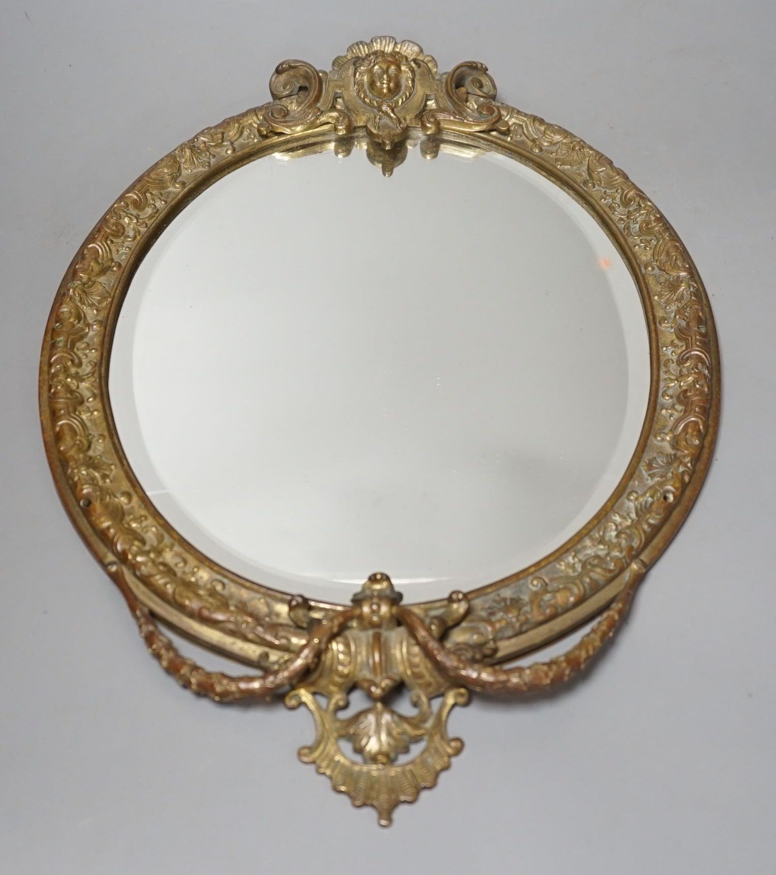 An early 20th century decorative gilt metal mirror, 41 cms high